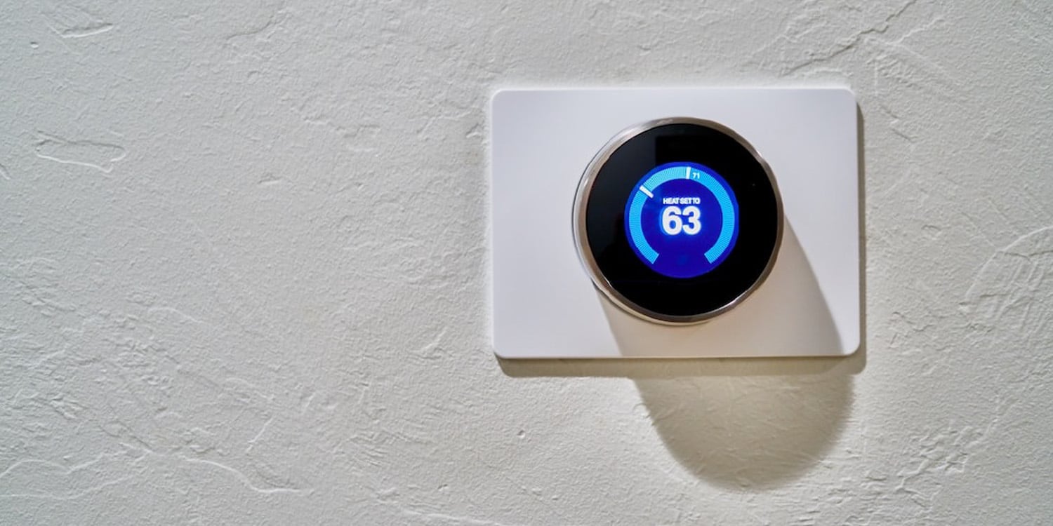 Nest thermostat Internet of Things (IoT) device installed on a wall