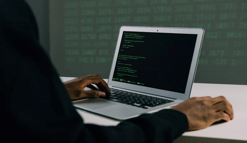 Man on laptop using password sniffing techniques